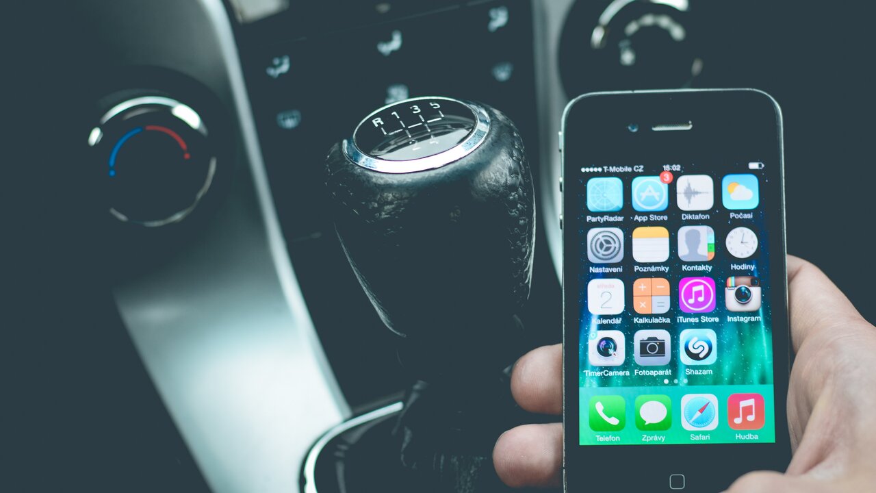 Hand hält Smartphone im Auto