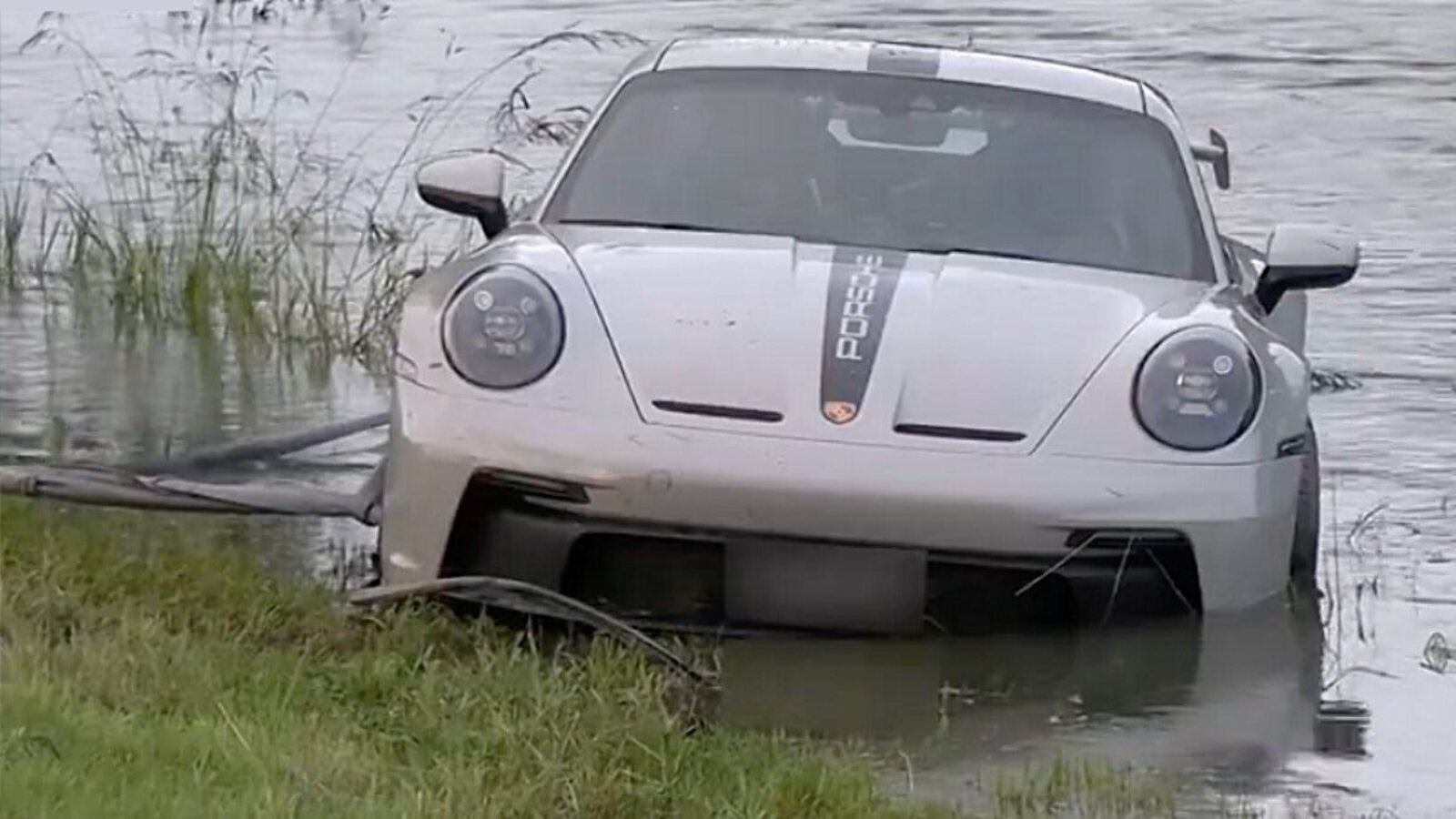 Der Porsche landete im Flussbett, nach wenigen Minuten war er mit Wasser vollgelaufen. Bild: Screenshot BRK News, Youtube