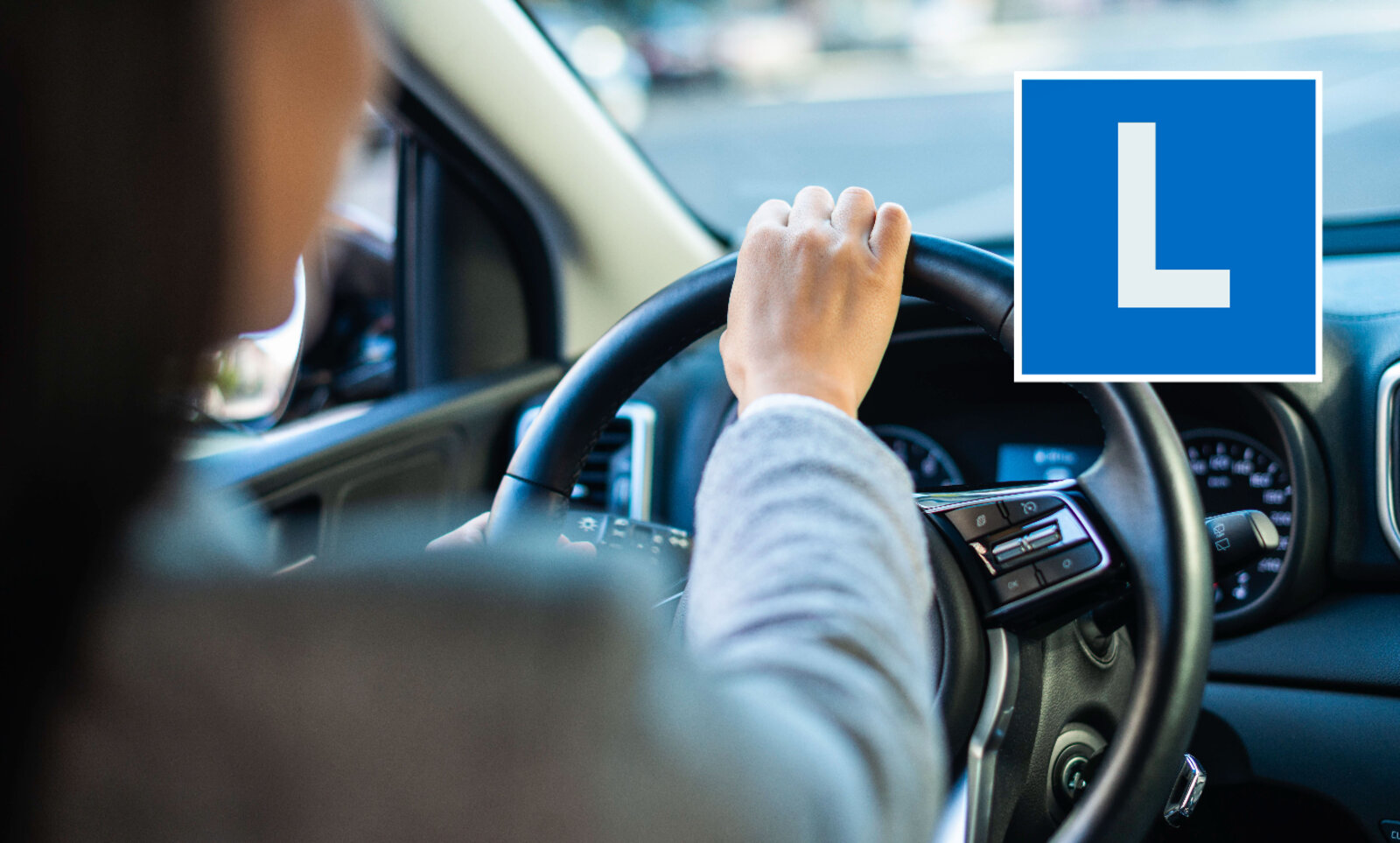 Fahrer mit Lenker in der Hand und L im Vordergrund