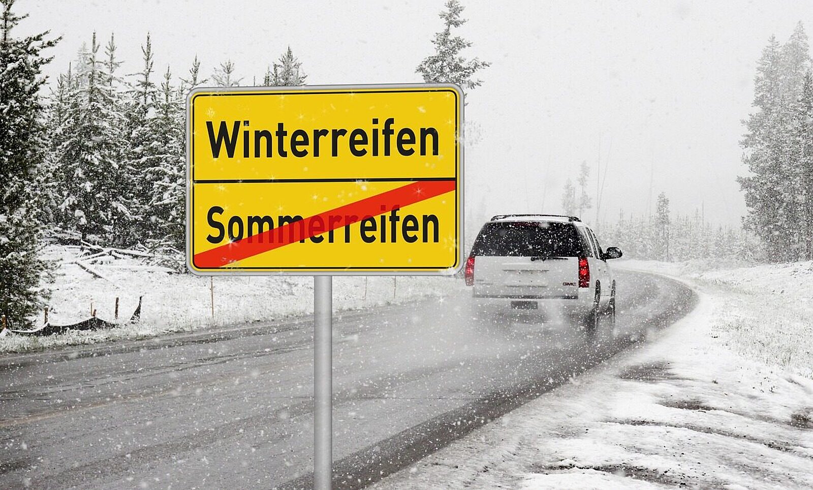 Auto auf der Strasse mit verschneitem Strassenrand.
