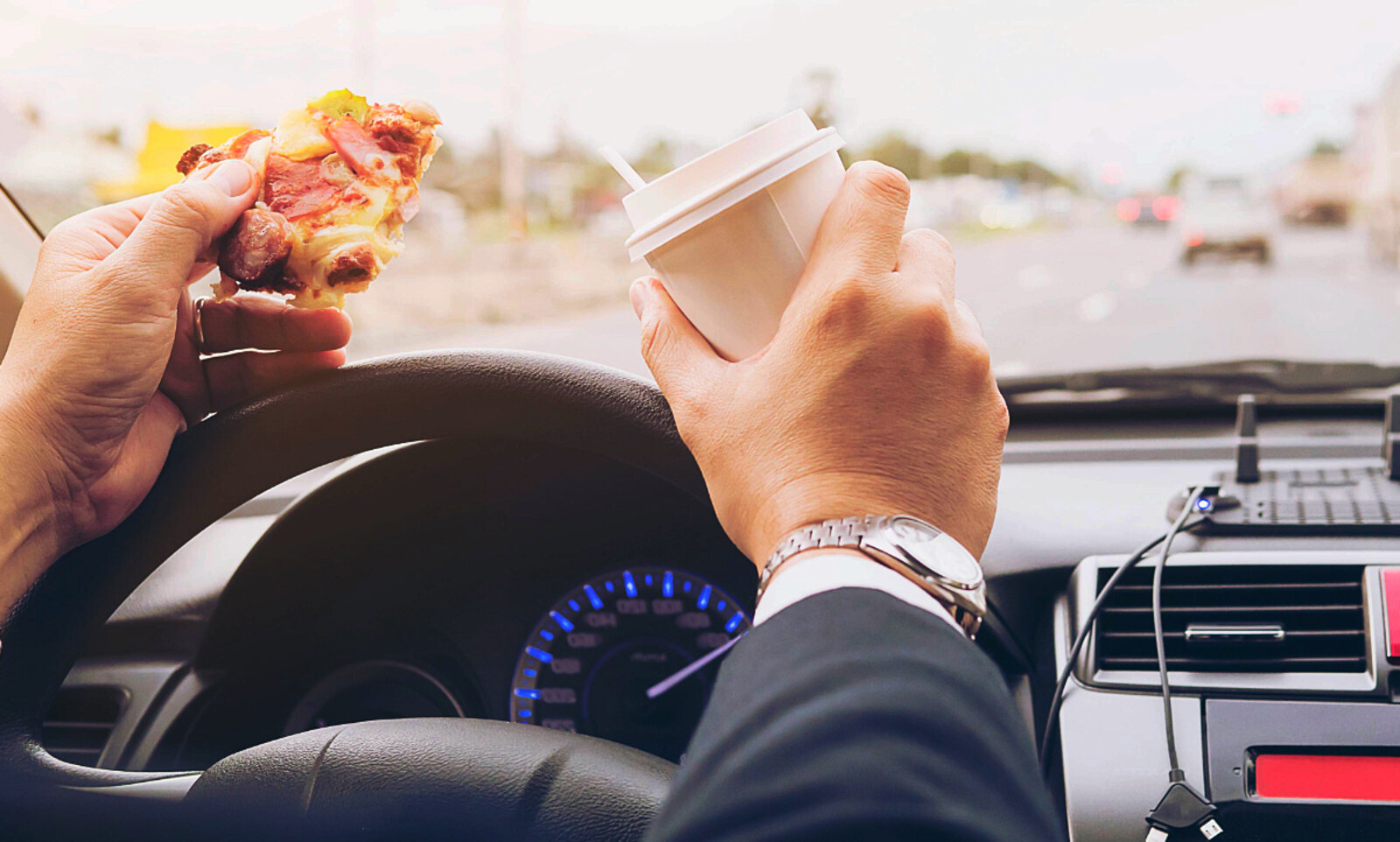 Die Pizza am Steuer zu essen, ist keine gute Idee. Wer erwischt wird, muss mit einer Verzeigung rechnen. Bild: freepik. 