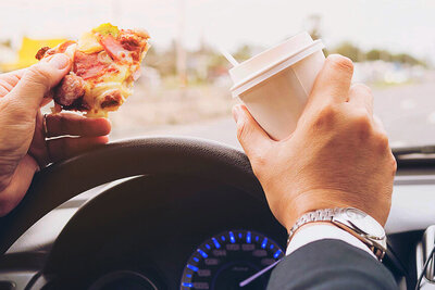 Die Pizza am Steuer zu essen, ist keine gute Idee. Wer erwischt wird, muss mit einer Verzeigung rechnen. Bild: freepik. 