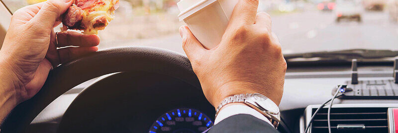 Die Pizza am Steuer zu essen, ist keine gute Idee. Wer erwischt wird, muss mit einer Verzeigung rechnen. Bild: freepik. 