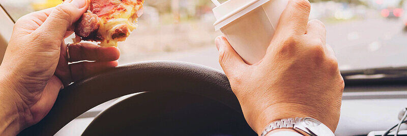 Die Pizza am Steuer zu essen, ist keine gute Idee. Wer erwischt wird, muss mit einer Verzeigung rechnen. Bild: freepik. 