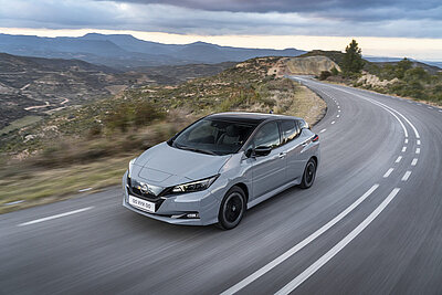 Das Elektroauto Nissan Leaf fährt auf einer Landstrasse.