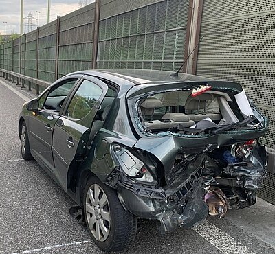 Nach der Kollision steht der stark beschädigte Peugeot in falscher Richtung auf der Autobahn. Im Hintergrund ist das unfallverursachende Fahrzeug, der Mercedes AMG zusehen. Bild: Kantonspolizei Zürich