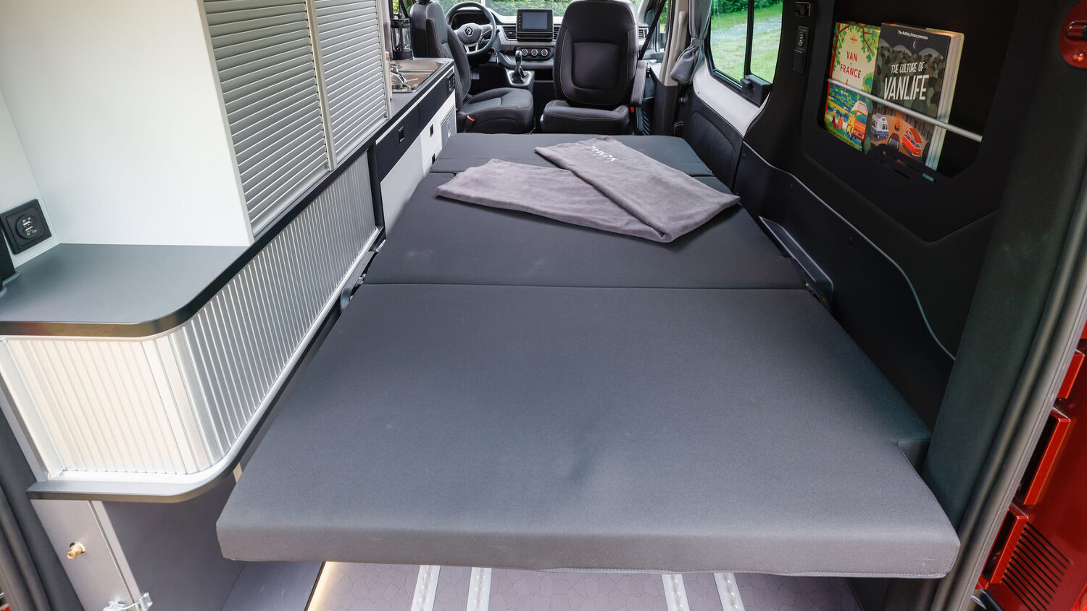 Die zum Bett umfunktionierte Rückbank im Camper Renault Trafic Spacenomad