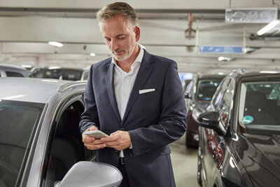 Ein Mann bucht einen Parkplatz auf seinem Smartphone