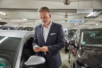 Ein Mann bucht einen Parkplatz auf seinem Smartphone