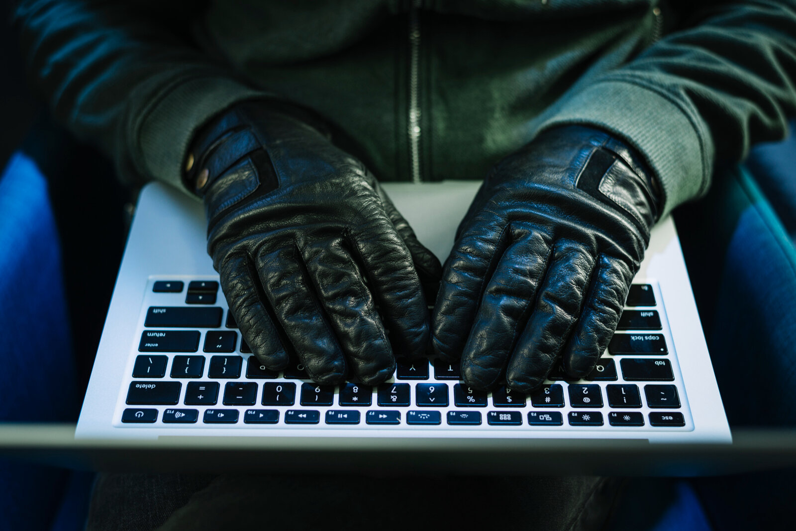 Behandschuhte Hände auf einer Lapttop-Tastatur
