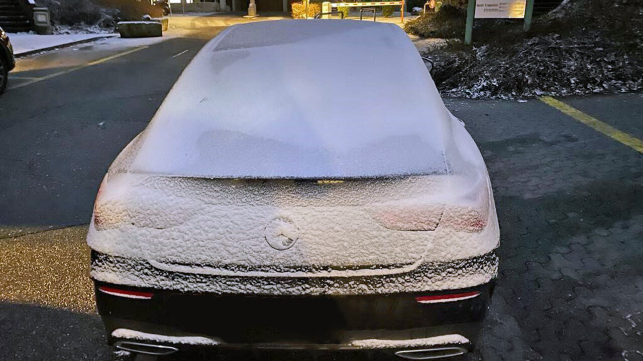 Verschneites Heck eines Autos.