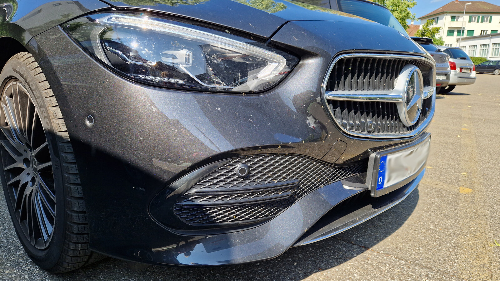 Die Front eines Autos mit zahlreichen Insektenüberresten.