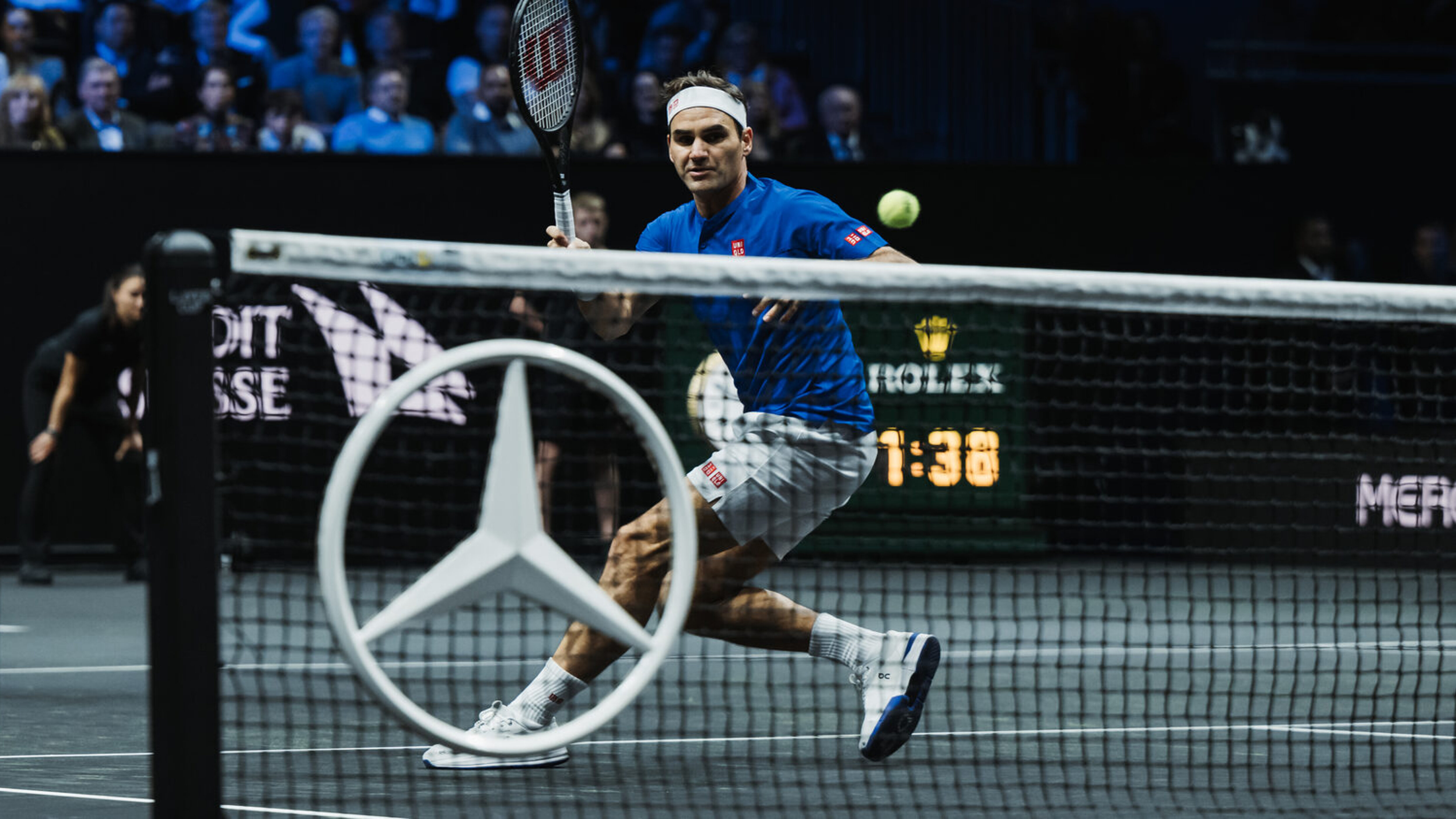 Roger Federer auf dem Tennisplatz im Vordergrund der Mercedes-Stern im Tennisnetz montiert
