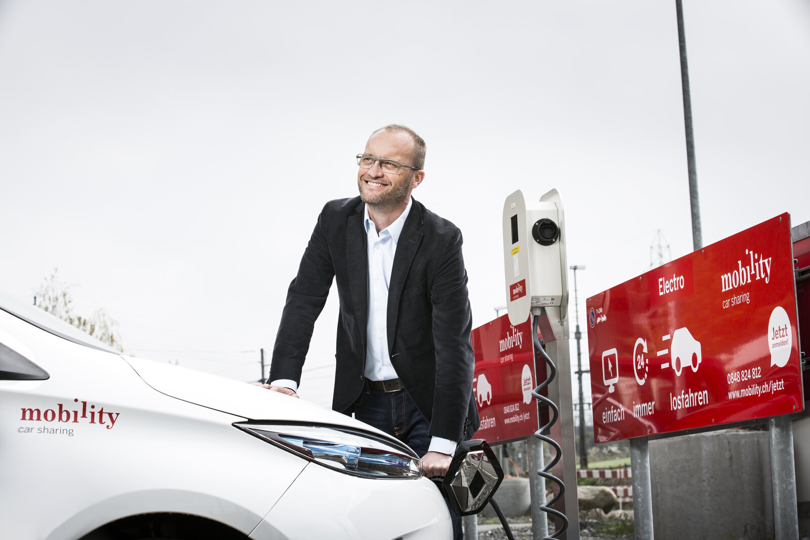 Mobility Genossenschaft CEO Roland Lötscher am Elektroauto einstecken