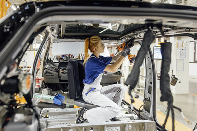 Mechanikerin baut Auto zusammane