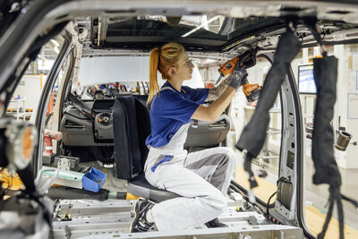 Mechanikerin baut Auto zusammane