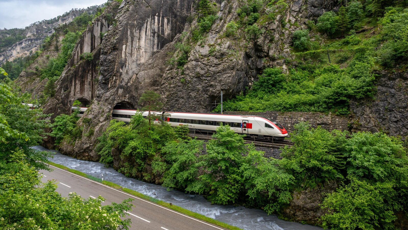 Ein Intercity fährt entlang eines Fluss durch die Natur