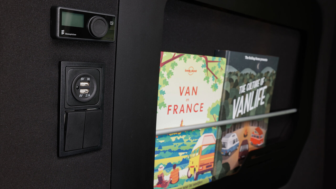 USB-Ports, Steckdose, Steuerung der Standheizung sowei Buch- und Tablethalterung im Camper Renault Trafic Spacenomad
