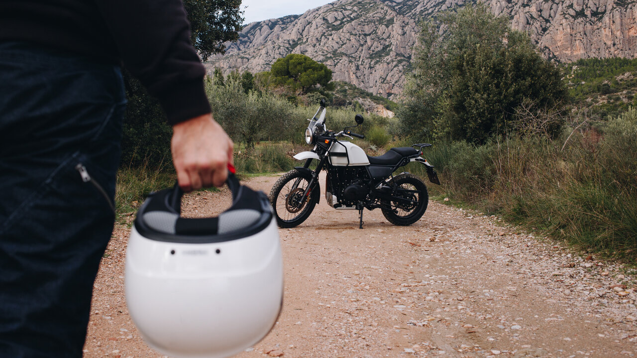 Person mit Helm vor einem Motorrad