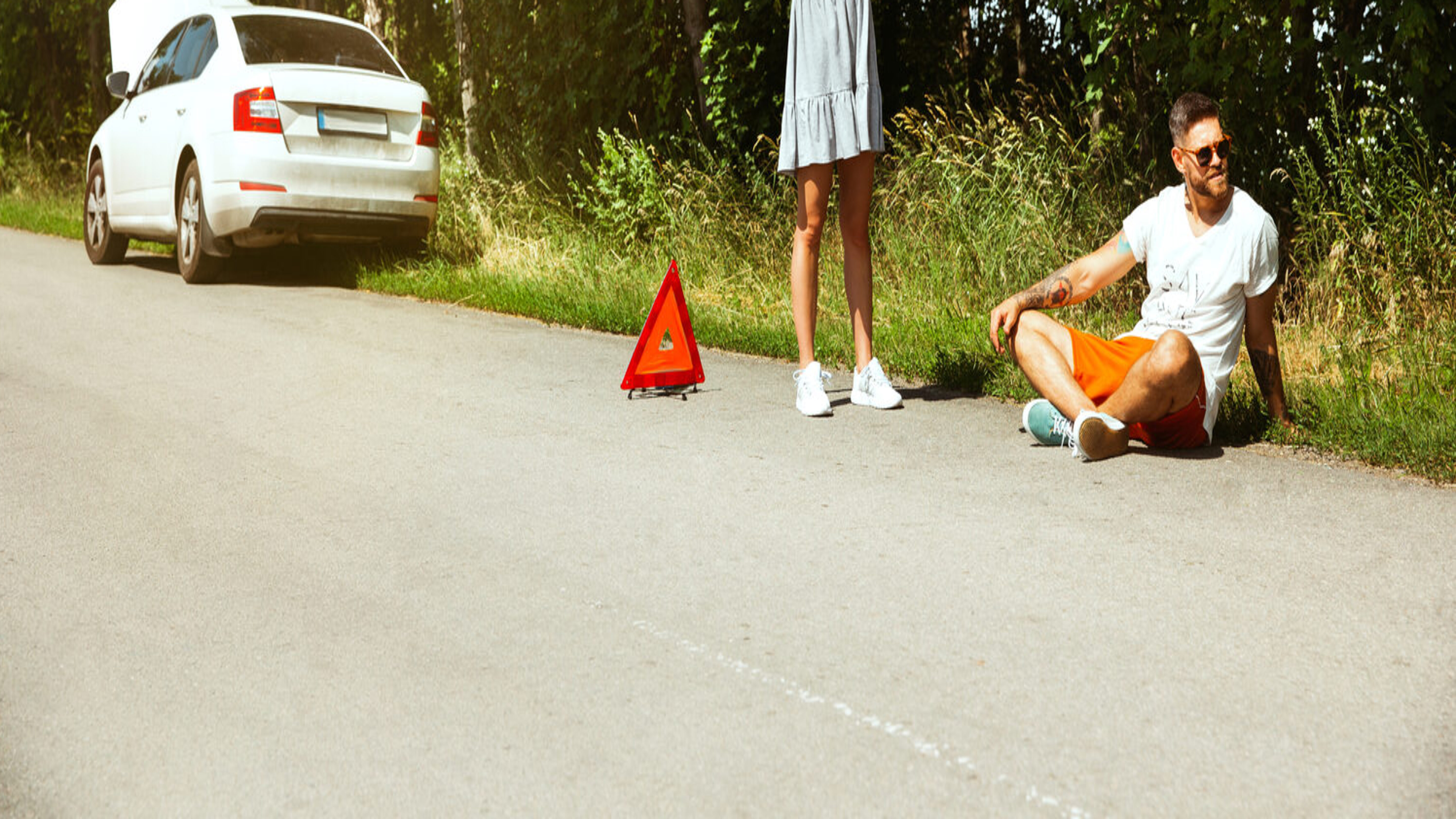 Junges Paar mit einer Autopanne und sie macht autostopp