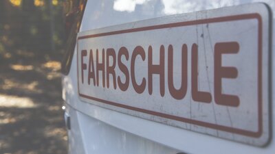Schriftzug Fahrschule an einem Auto