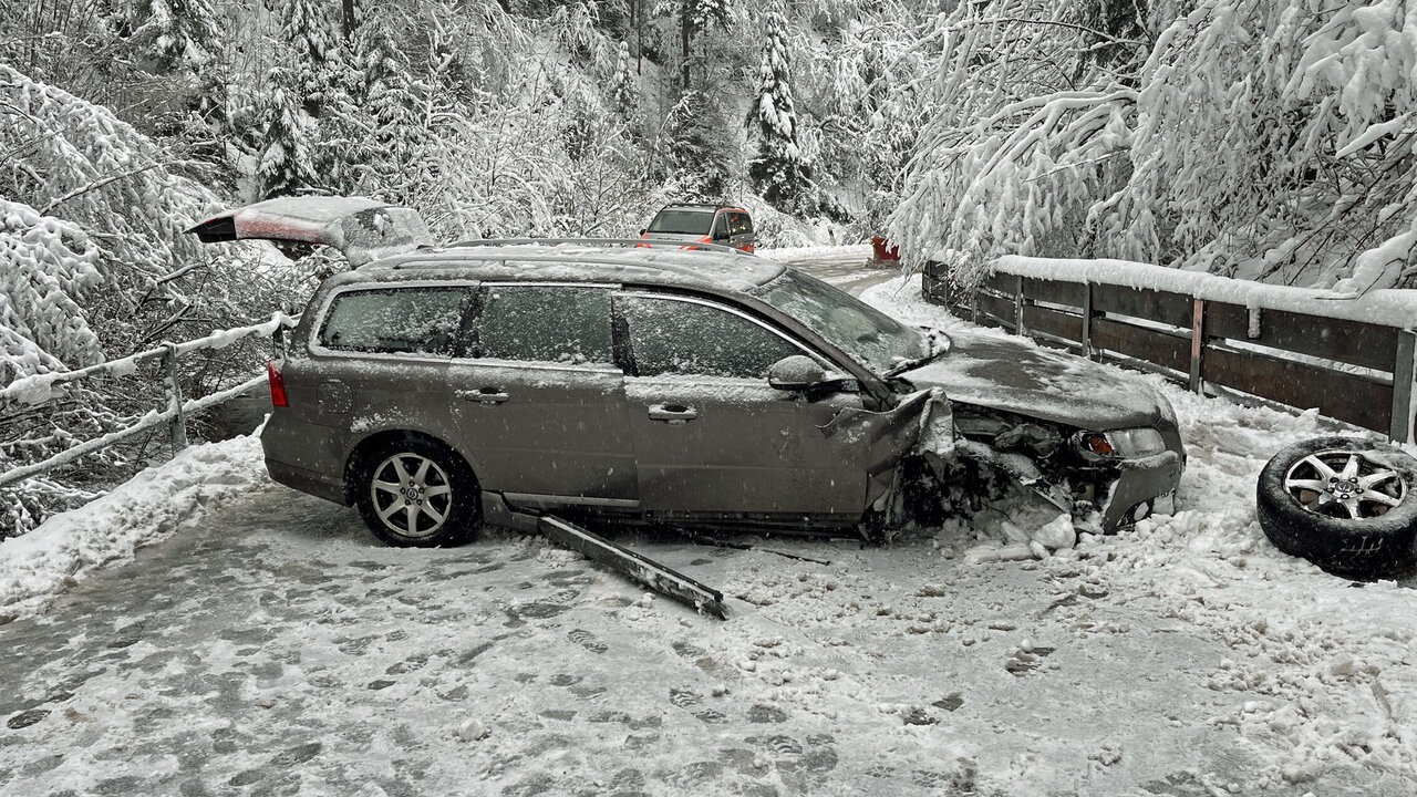Verunfalltes Auto auf vereister Strasse.