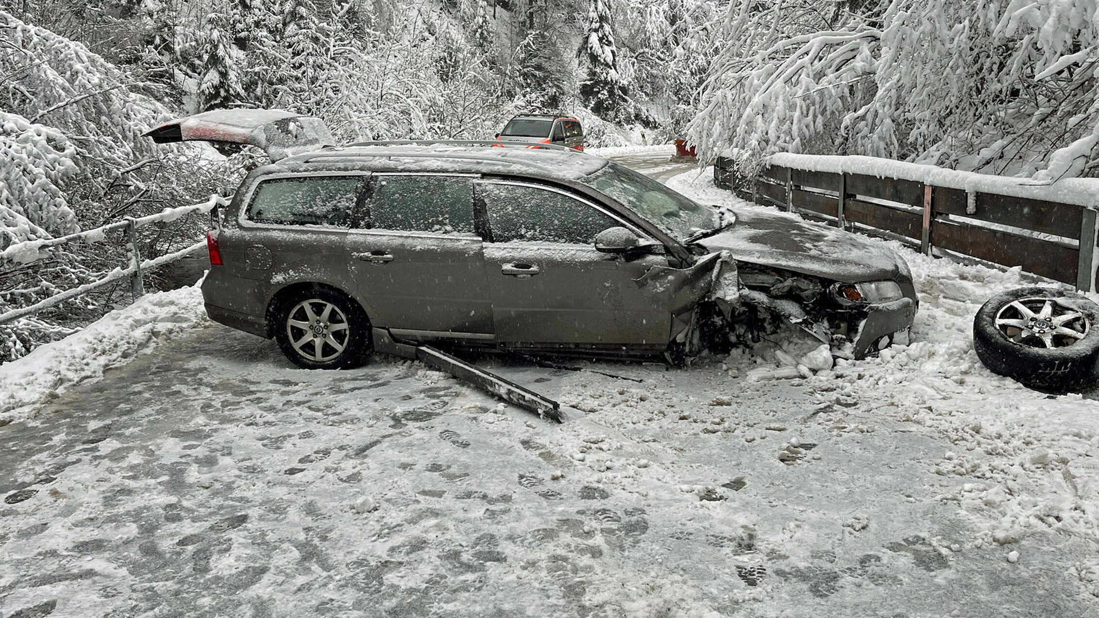 Verunfalltes Auto auf vereister Strasse.