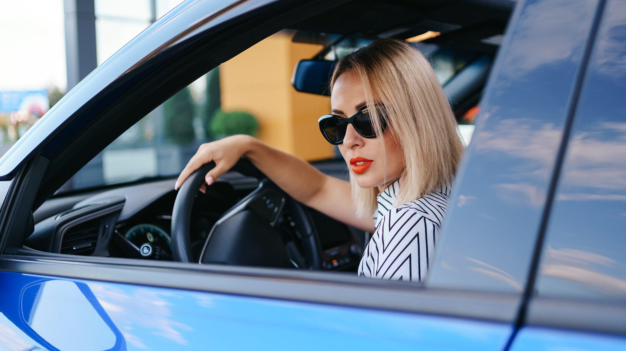 Frau mit Sonnenbrille im Auto