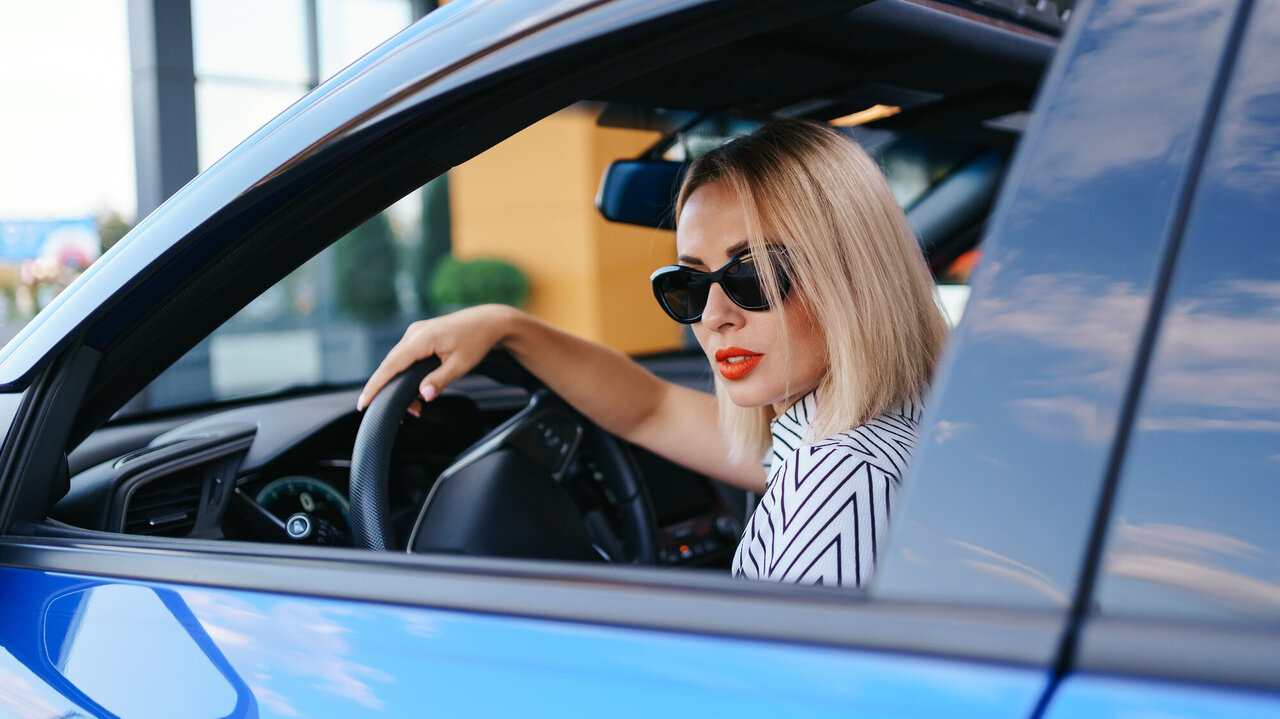 Frau mit Sonnenbrille im Auto