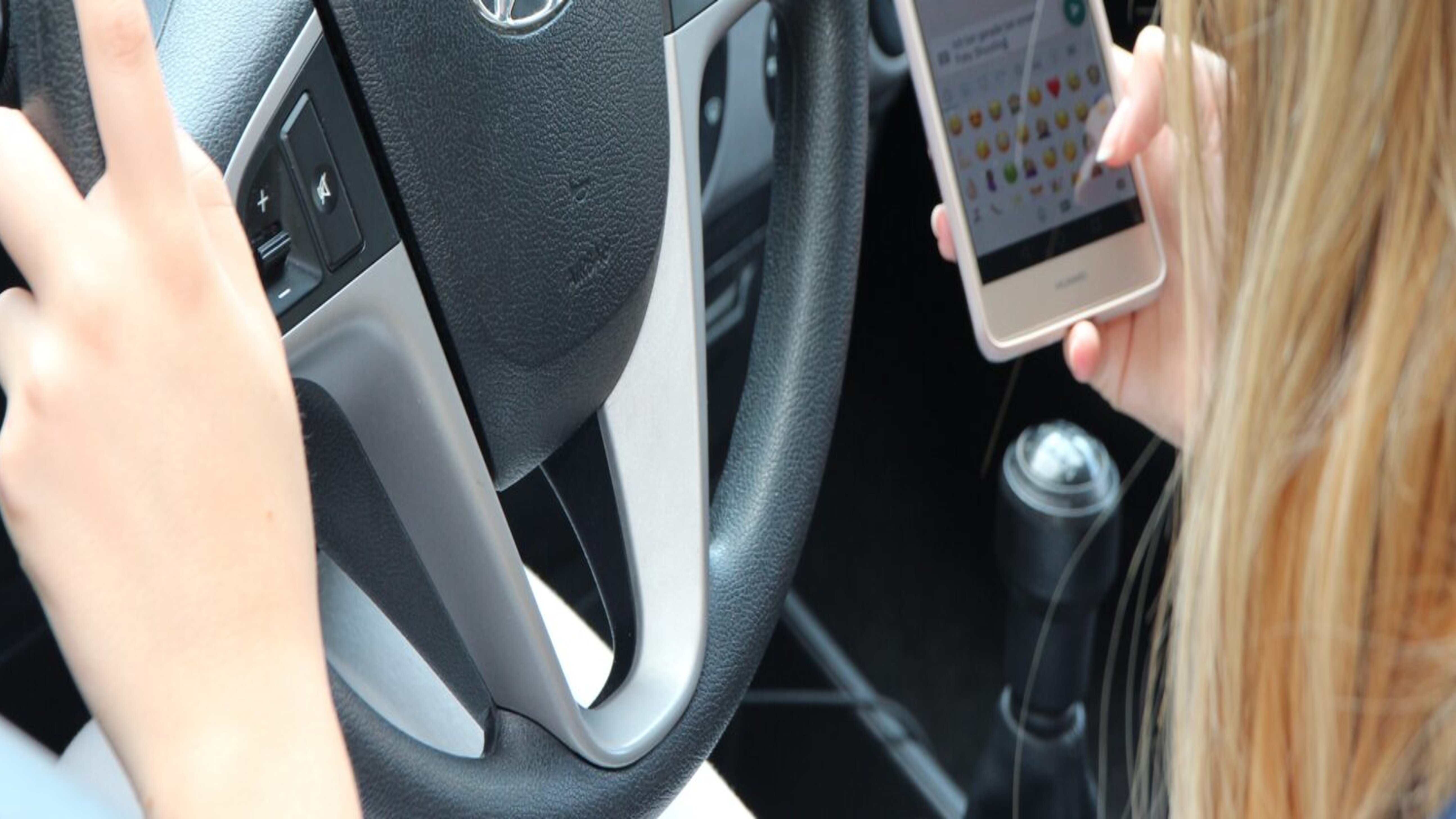 Frau am Handy beim Fahren