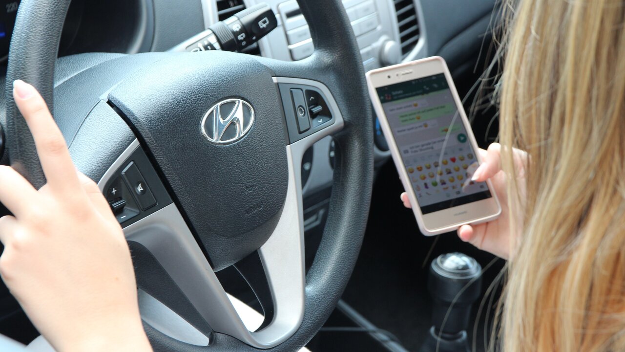 Frau am Handy beim Fahren