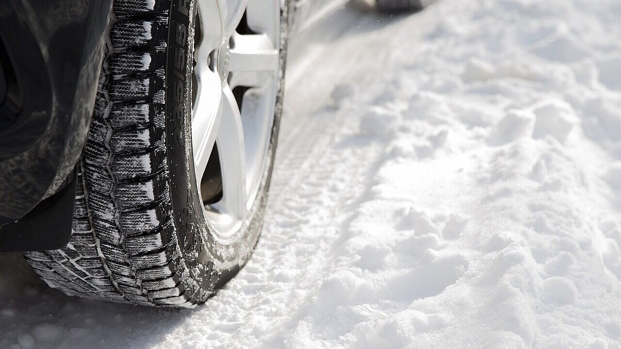 Autoreifen auf schneebedeckter Strasse.