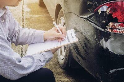 Verischerungsagent untersucht Unfall
