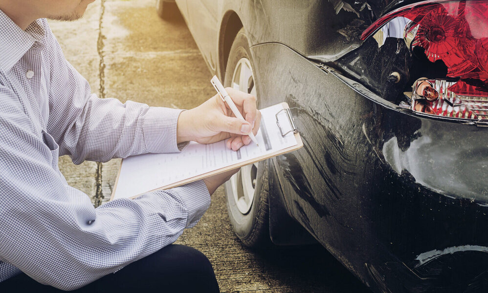 Verischerungsagent untersucht Unfall