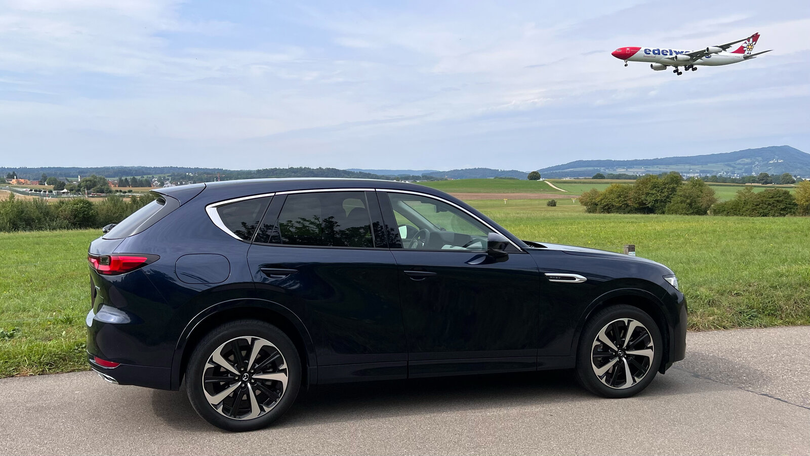 Seitenansicht das Mazda CX-60 mit Flugzeug im Anflug