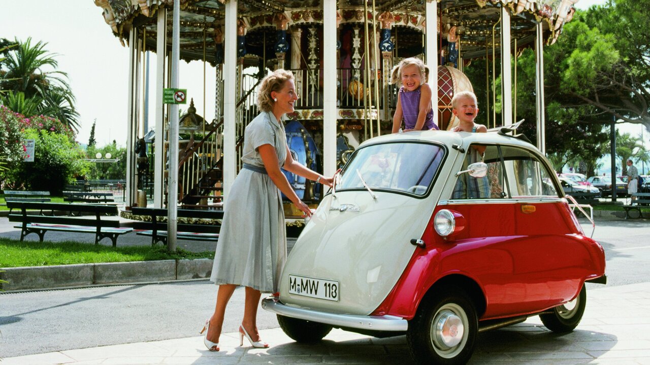BMW Isetta mit Mutter und Kindern vor einem Karusell