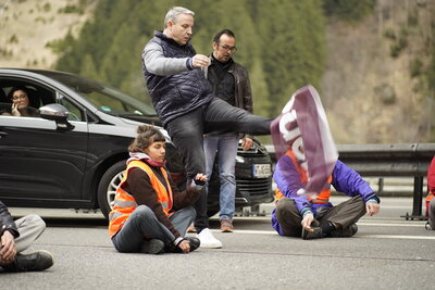 Unbeteiligter Kick in Demonstrationsplakat von Klimaklebern