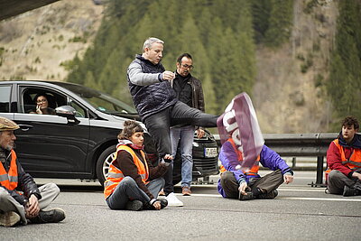 Unbeteiligter Kick in Demonstrationsplakat von Klimaklebern