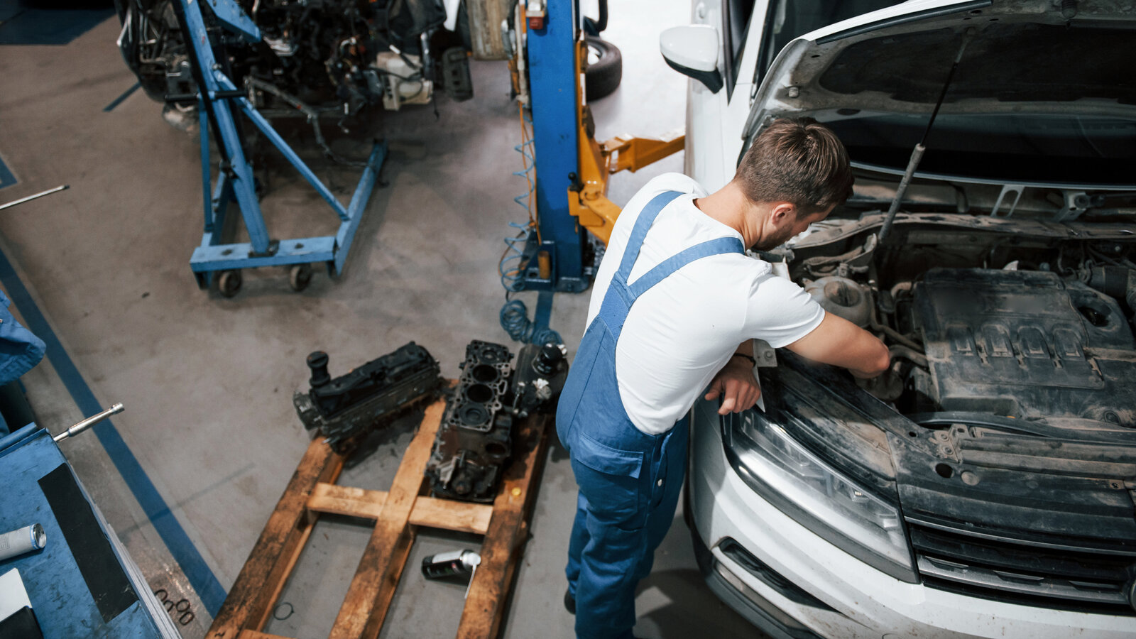Ein Mechaniker arbeitet im Motorraum eines Autos