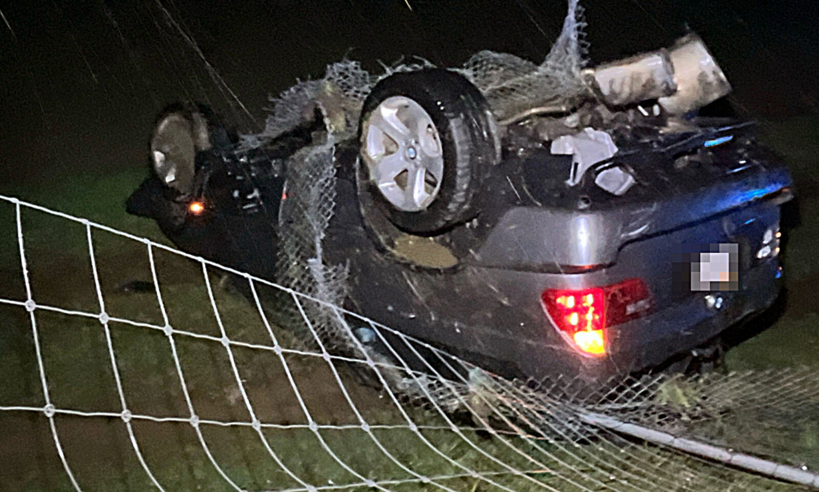 Nach der Kollision mit dem Wildschutzzaun blieb der BMW auf dem Dach in der Wiese liegen. Bild: Kantonspolizei Solothurn