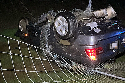 Nach der Kollision mit dem Wildschutzzaun blieb der BMW auf dem Dach in der Wiese liegen. Bild: Kantonspolizei Solothurn