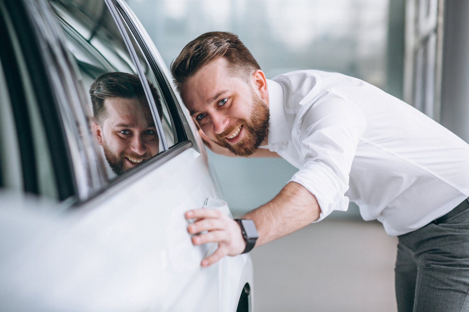 ein Mann freut sich über sein Auto.