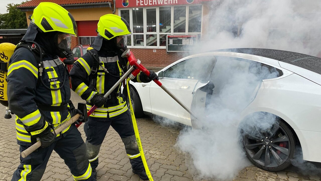Feuer bekämpft ein Feuer in einem Tesla mit einer Löschlanze