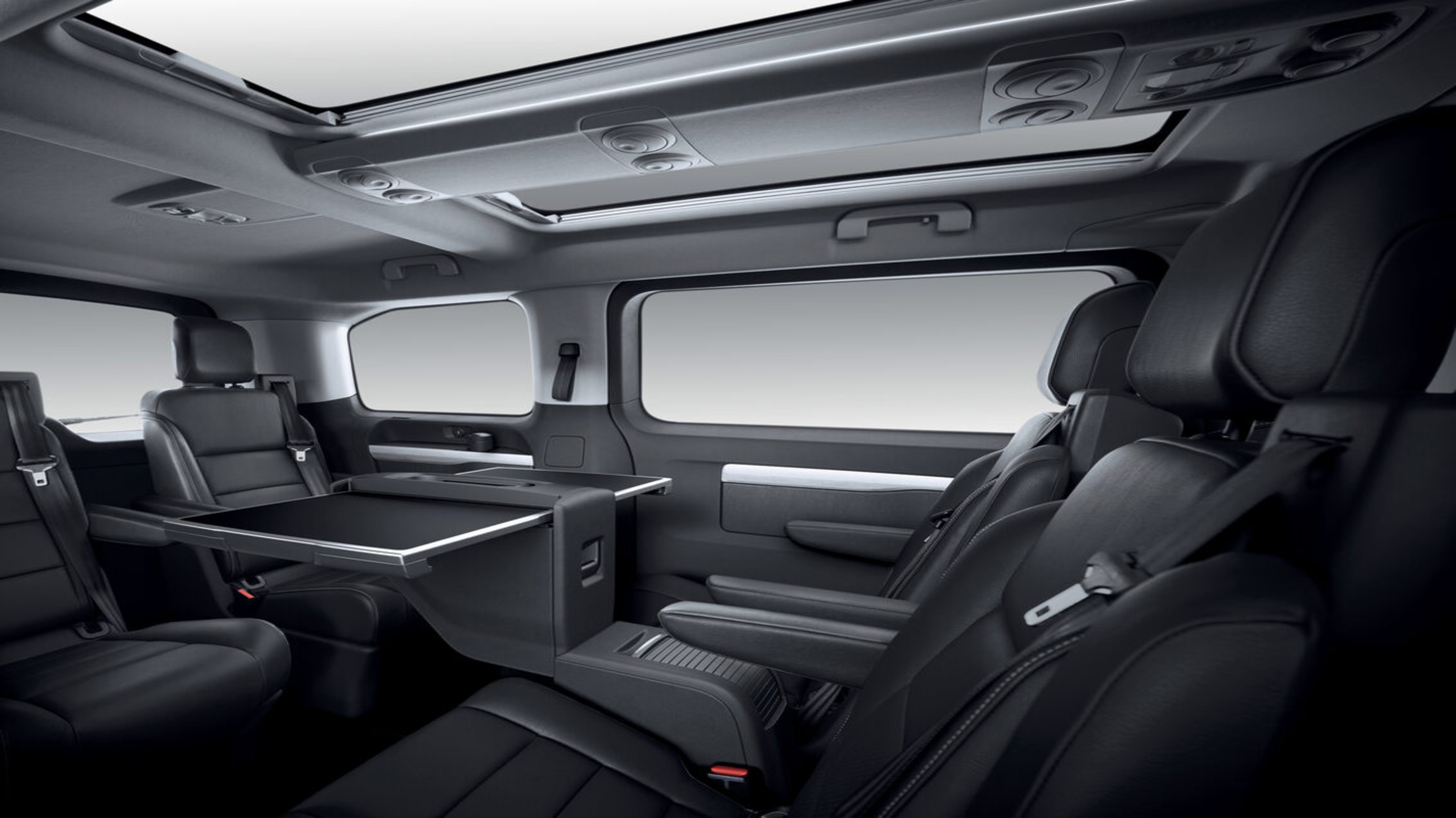 Der Innenraum des Peugeot e-Traveller in Lounge-Bestuhlung mit Tisch.