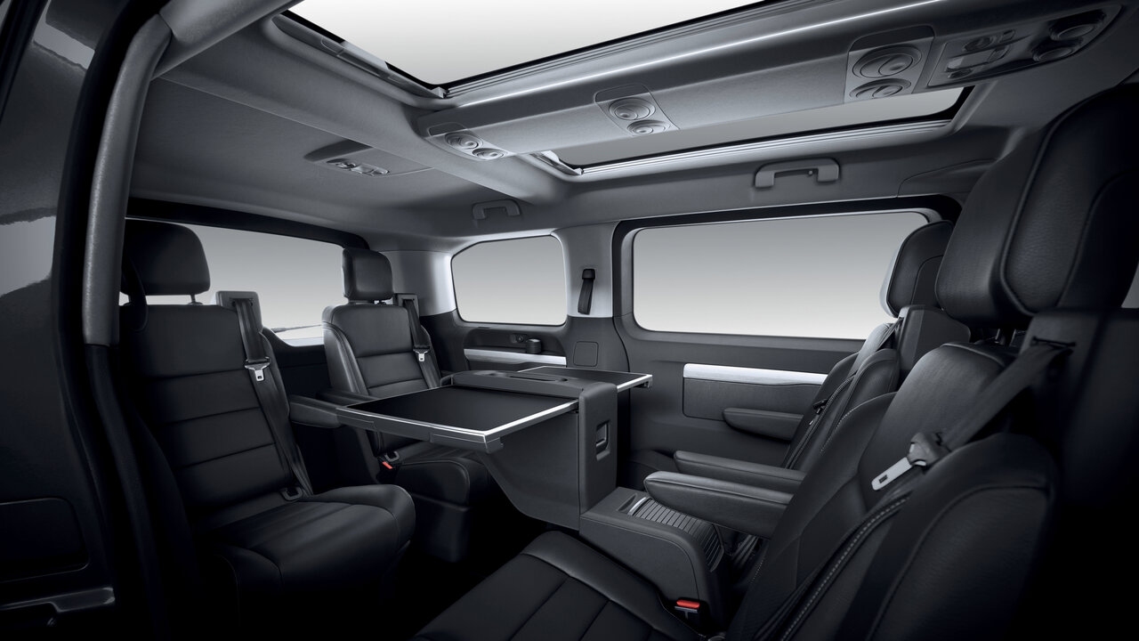 Der Innenraum des Peugeot e-Traveller in Lounge-Bestuhlung mit Tisch.
