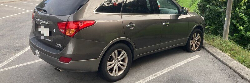 Auto auf Parkplatz mit plattem Reifen