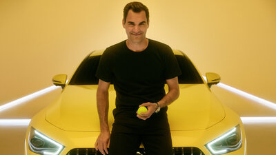 Roger Federer lehnt vor einem gelbem Mercedes-Benz