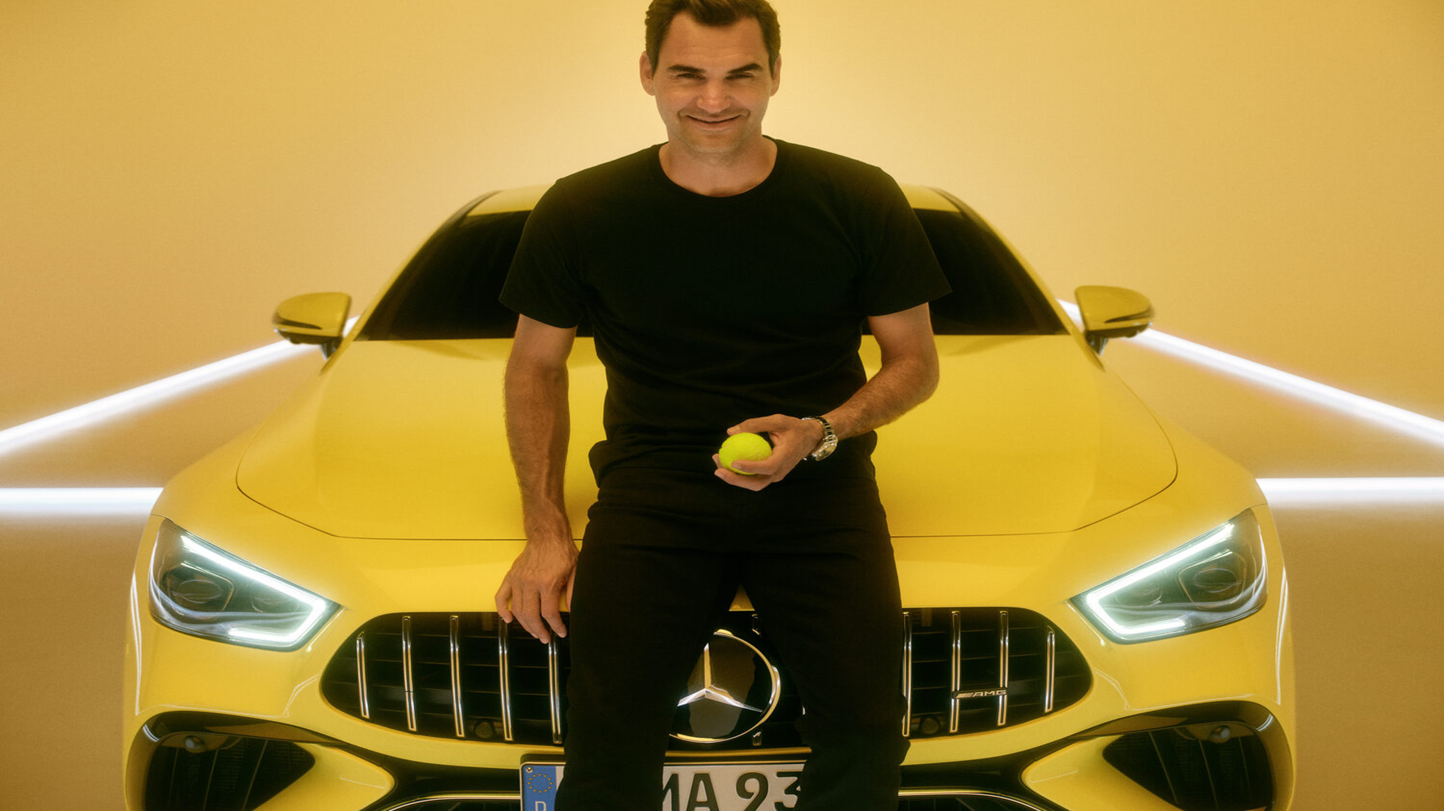 Roger Federer lehnt vor einem gelbem Mercedes-Benz