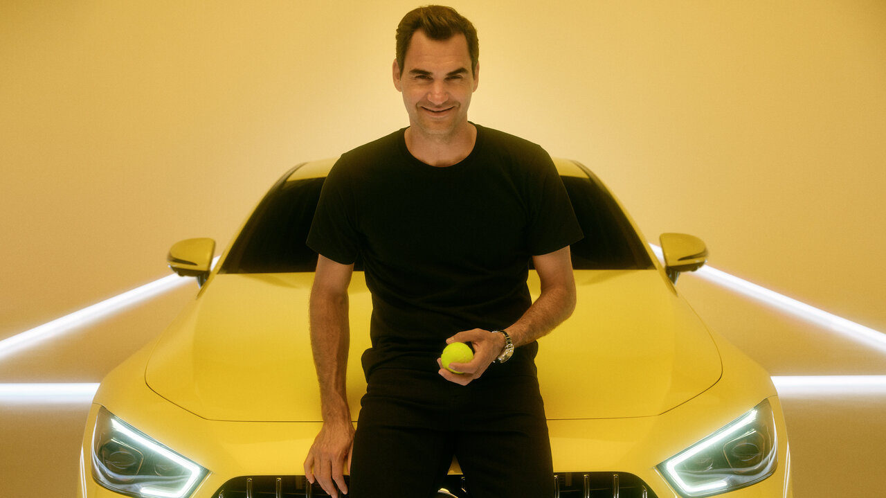 Roger Federer lehnt vor einem gelbem Mercedes-Benz