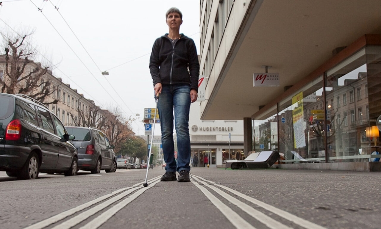 Signalisiert eine blinde Person mit ihrem weissen Stock, dass sie die Strasse überqueren will, dann ist sie gegenüber dem restlichen Verkehr immer vortrittsberechtigt. Bild: obs/Schweizerischer Zentralverein für das Blindenwesen SZB
